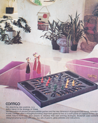 A vintage product advertisement for the Contigo Contingency Alignment Game, showing the black plastic game tray with colorful wooden and glass pieces, a matching black storage case, and several decorative glass goblets on a purple surface in a modern living room setting.