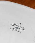 Close-up of a white ceramic Corning Ware 4-quart range and microwave oven dish, showing the black printed model number P-84-B and manufacturer text.